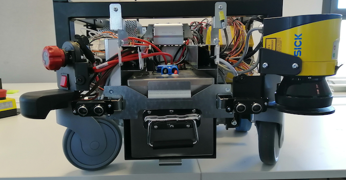 The battery is enclosed in a steel box and held by a retaining plate to prevent movement and connected to a DP9 connector and DC 24V wires.