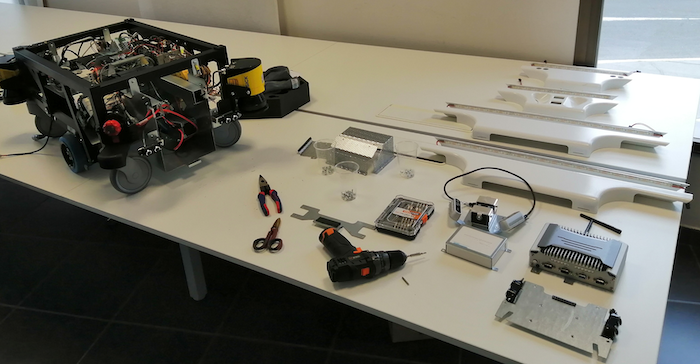 Final figure depicting the main components contained inside of the MiR100 robot, alongside the tools used for the teardown.