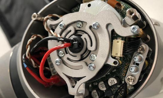 L) Opening a joint we find the harmonic drive, on top of the PCB for communication and power distribution. And the release solenoid.